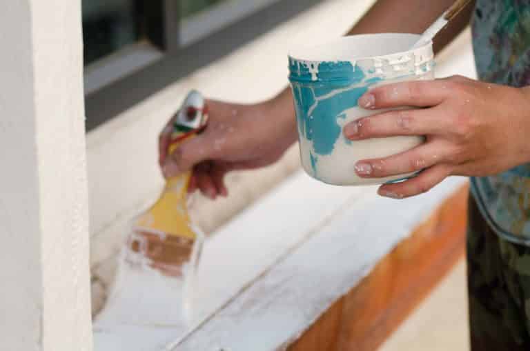 Worker painting wood with paint brush