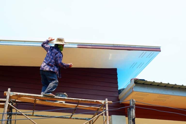 Painter is painting the roof in the hot weather of summer