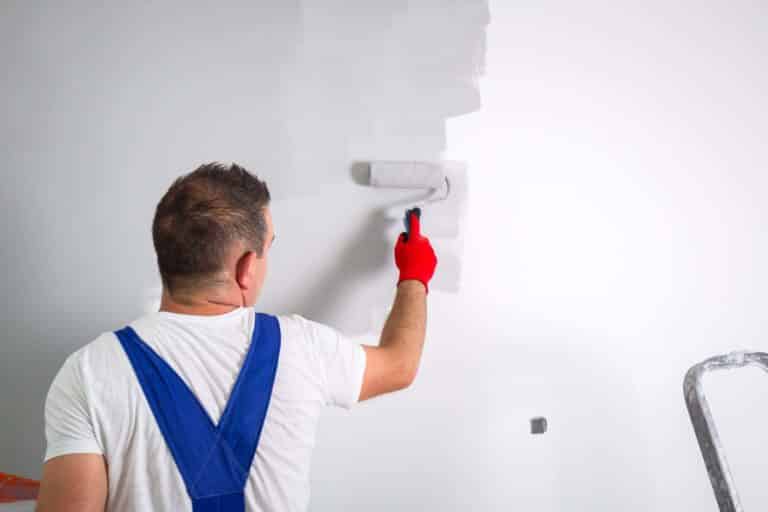 Painter man at work with a paint roller